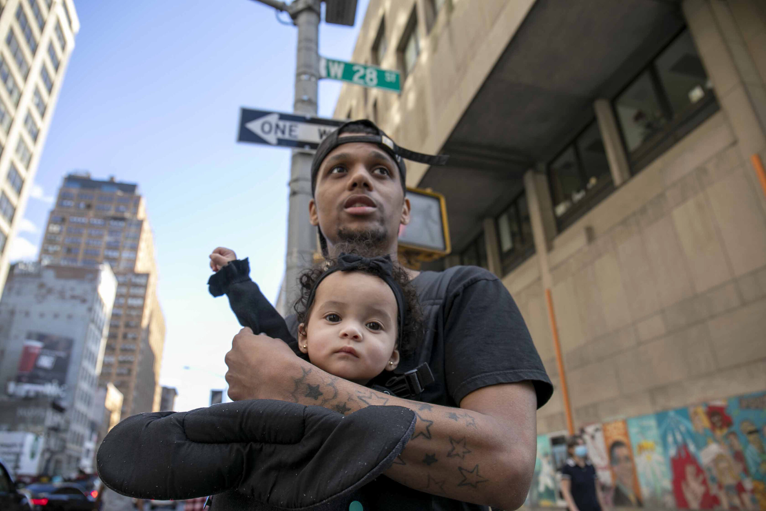  Photo By: Diana Cervantes  Joshua holds his 8-month-old daughter, Luna, as protestors march in Manhattan demanding justice for George Floyd who was killed by Minneapolis Police on May 25.  &nbsp;Joshua said he wasn’t trying to make Luna raise her fi