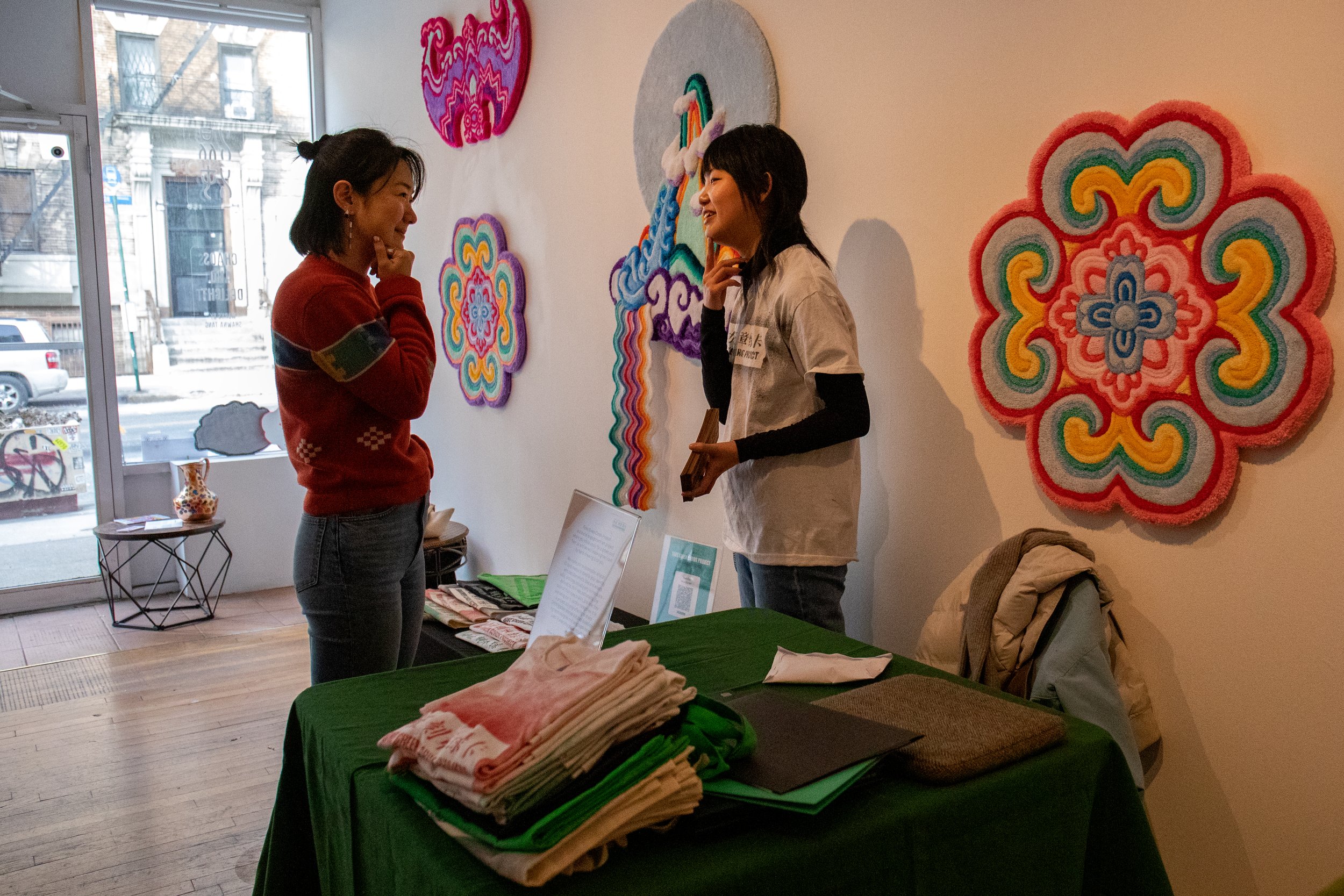  Youkun Zhou, left, and Xuan Liu discuss their setup and prepare before the opening of the Market of Dreams. The fair featured various artists and vendors. 