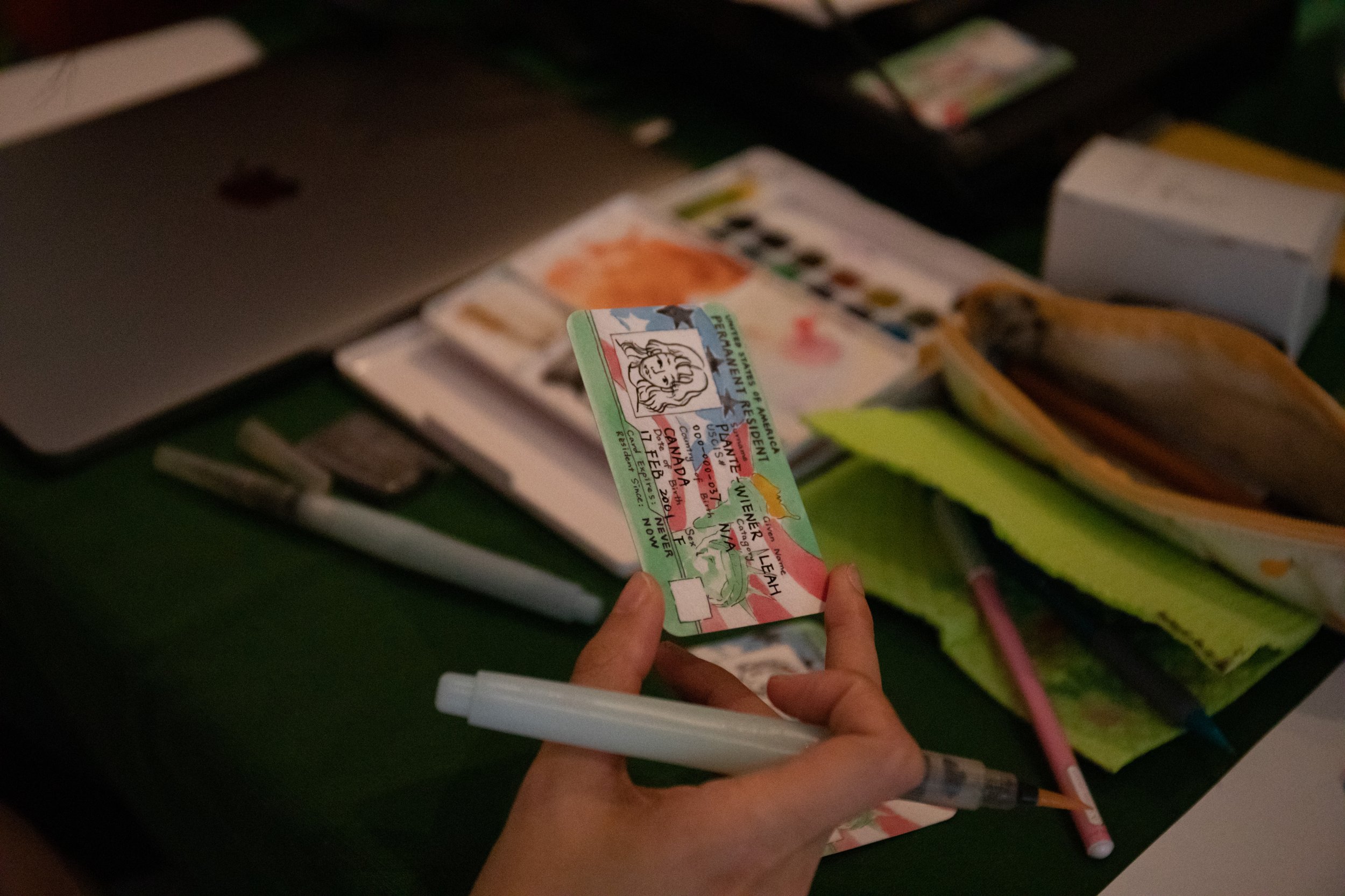  Xuan Liu adding color to a green card with color pencils. 