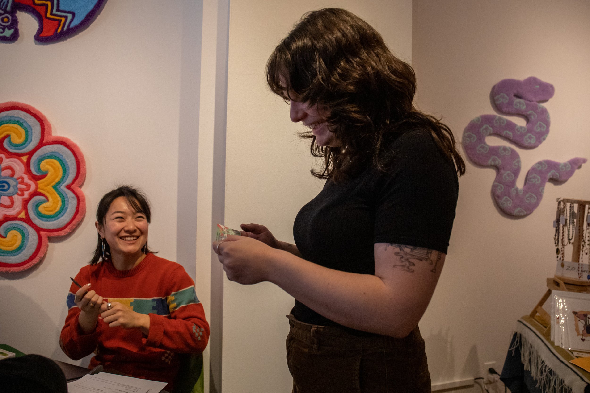  Leah Plante-Wiener smiles as Youkun Zhou hands her the completed fake green card. Plante-Wiener is from Montreal, Canada and has lived in NY for four and half years. 