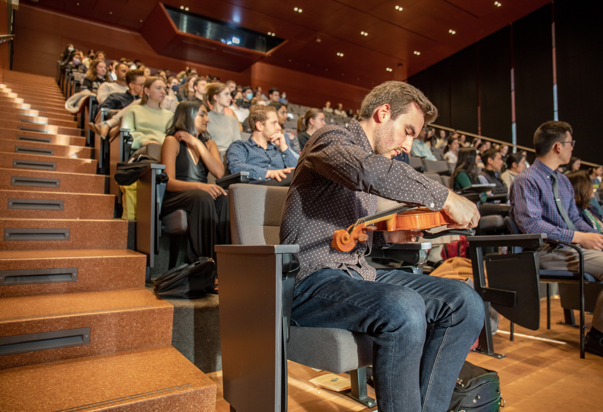 Evan Wright, first year medical student at Columbia University takes his seat after playing Johann Sebastian Bach’s Largo Espressivo on the violin as a personal tribute and gratitude to the donors that donated their bodies for science. Wright was on