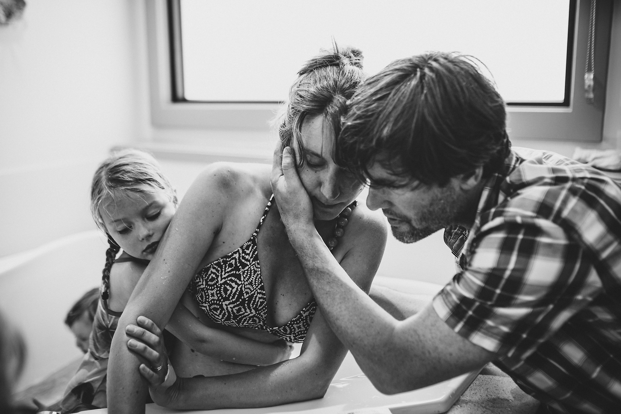 Husband and daughter support mother in tub