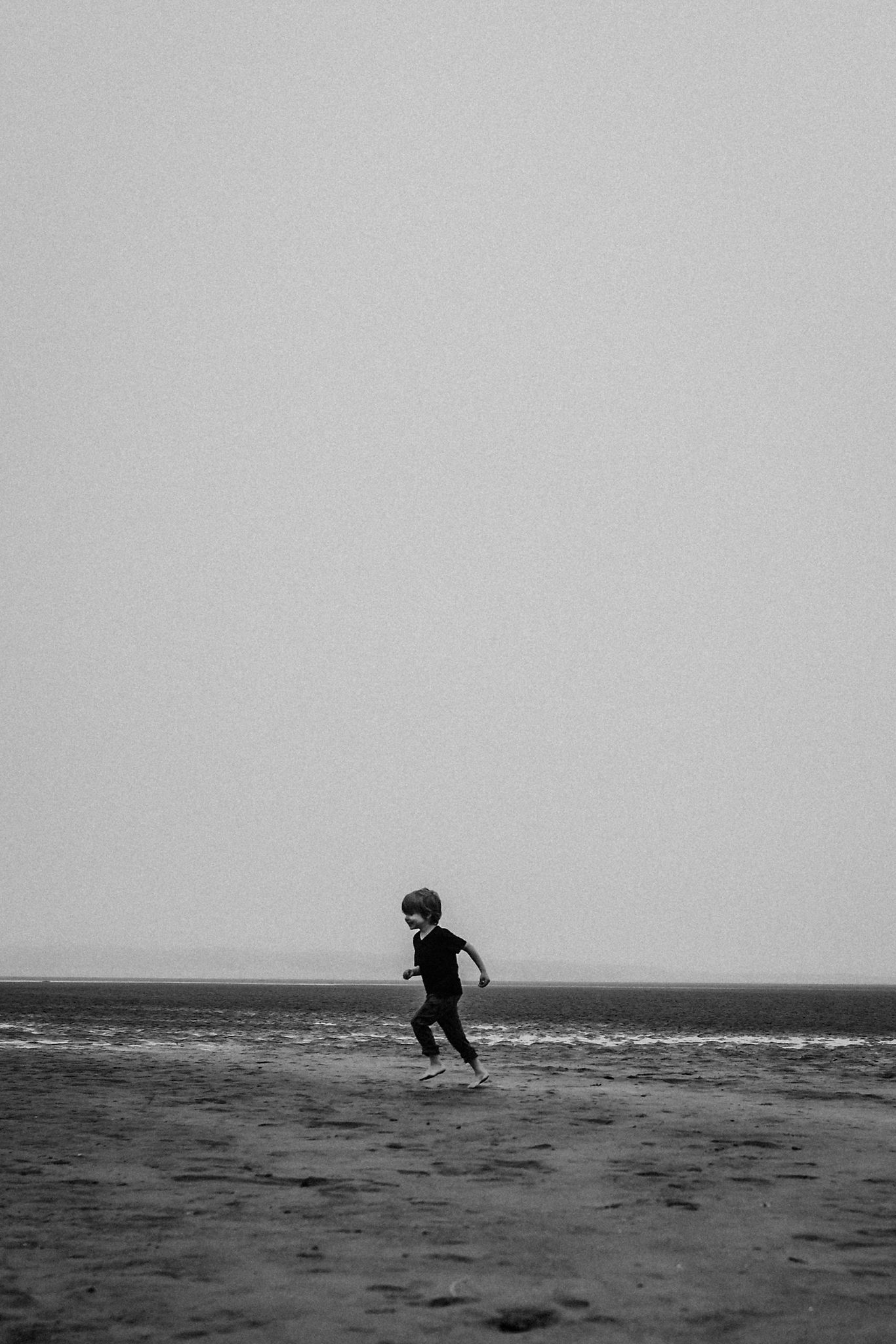 Boy running on beach in Lincoln City Oregon