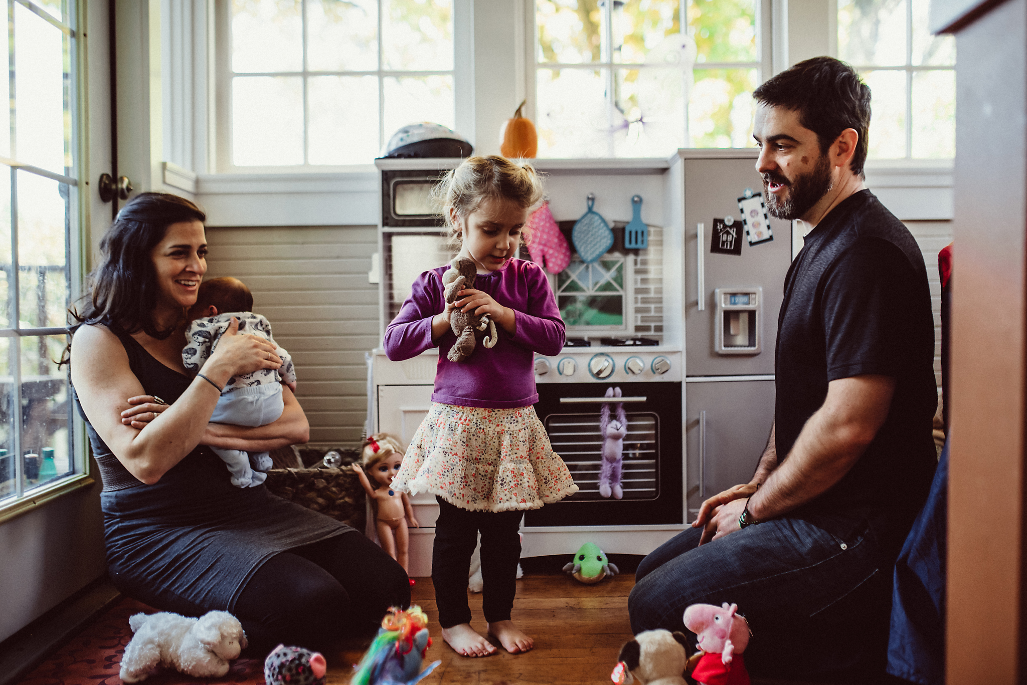 Family has a tea party in play kitchen