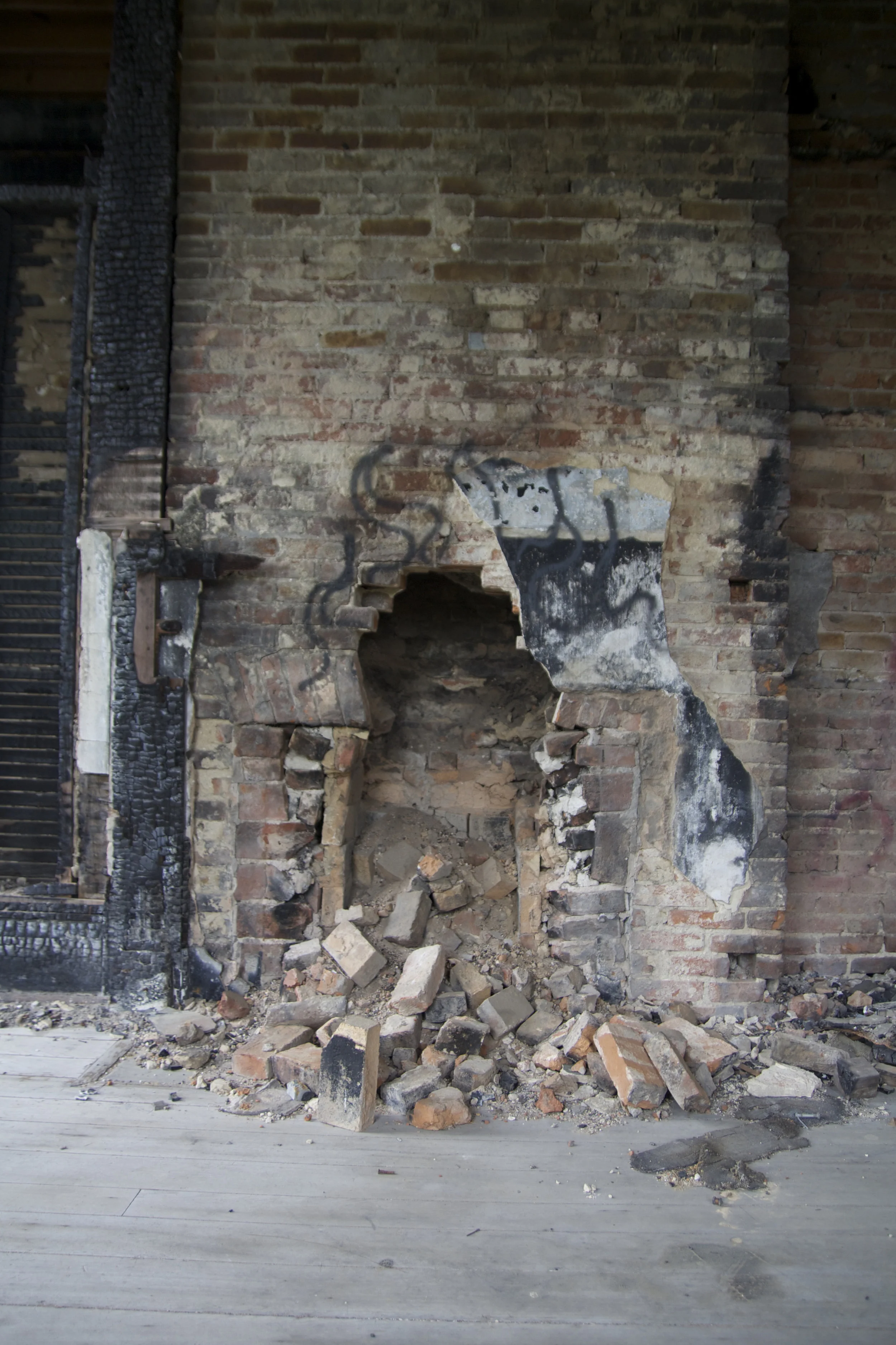 Another view of a 2nd floor bedroom with fire damage to the wood portions of the room and vandalism to the interior hearth. I wonder how many cold evenings were warmed by this fireplace before heat and electricity were available.