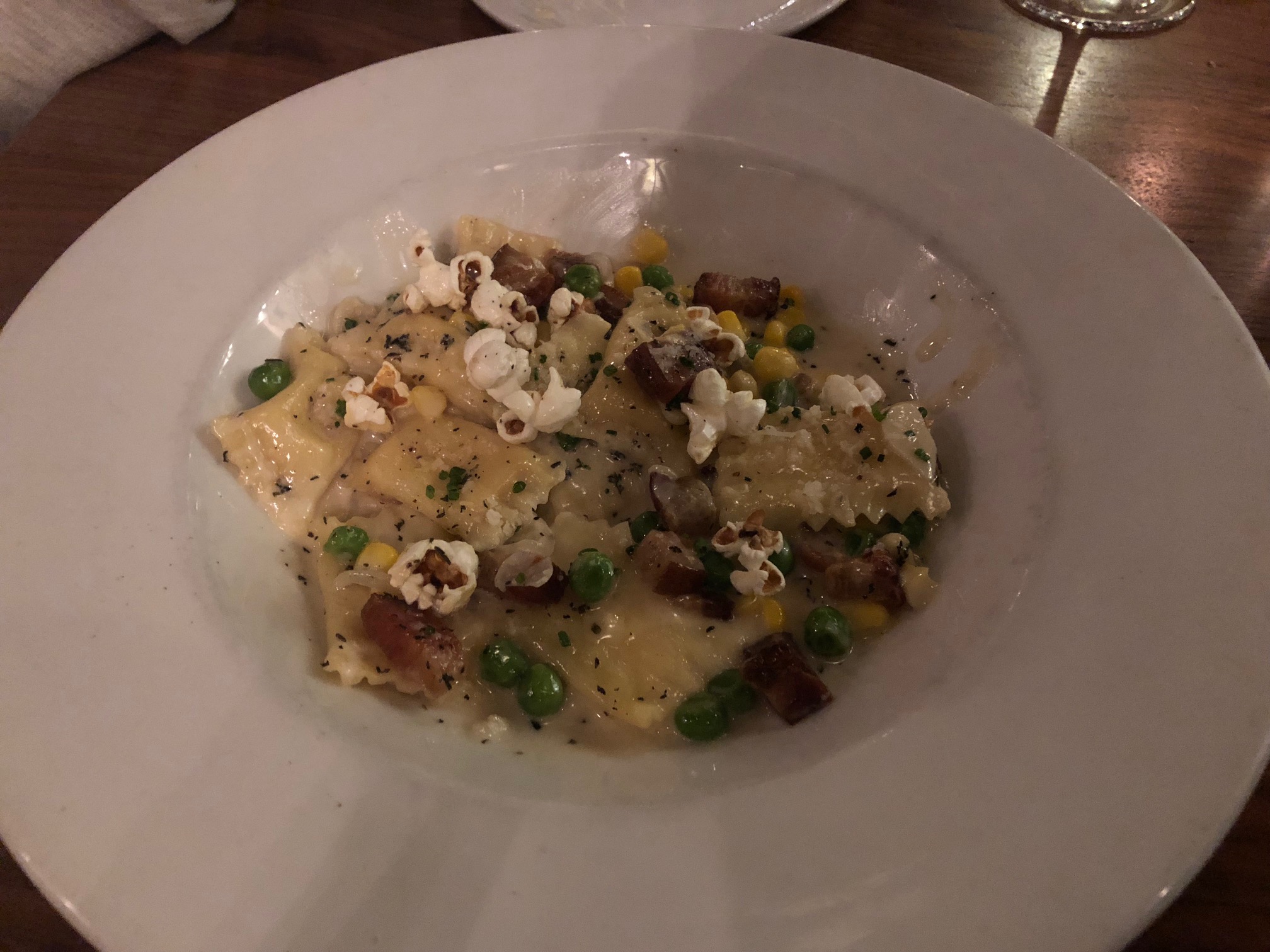  A picture of one entree we elected to share…the House Made Agnolotti with corn & roasted garlic stuffed pasta, bacon, peas, cream, parmesan, popcorn. The popcorn is what tipped us over…very unique and a nice, added texture. Image Credit: Dan Meyers  