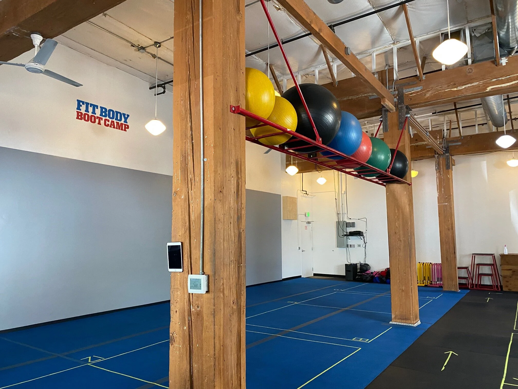  Part of the interior at Fit Body Boot Camp. Separate square spaces have been created for each person attending boot camp directly (vs. the zoom option). This, plus other mask mandate measures, constant cleaning of surfaces, high ceiling air circulation and more make the interior space at Fit Body Boot Camp comfortable indeed. Image Courtesy: Dan Meyers 