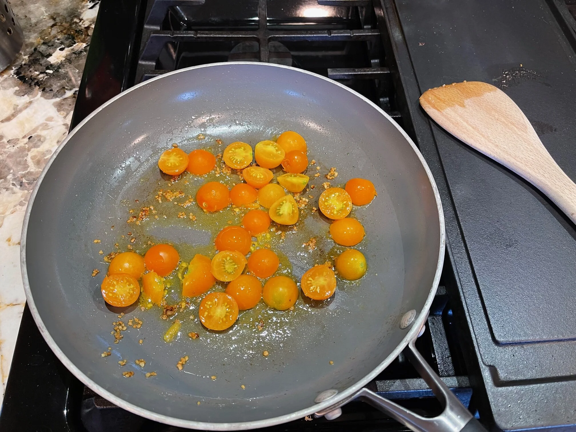 Halve the cherry tomatoes and begin cooking them in the garlic/olive oil. Image Courtesy: Dan Meyers