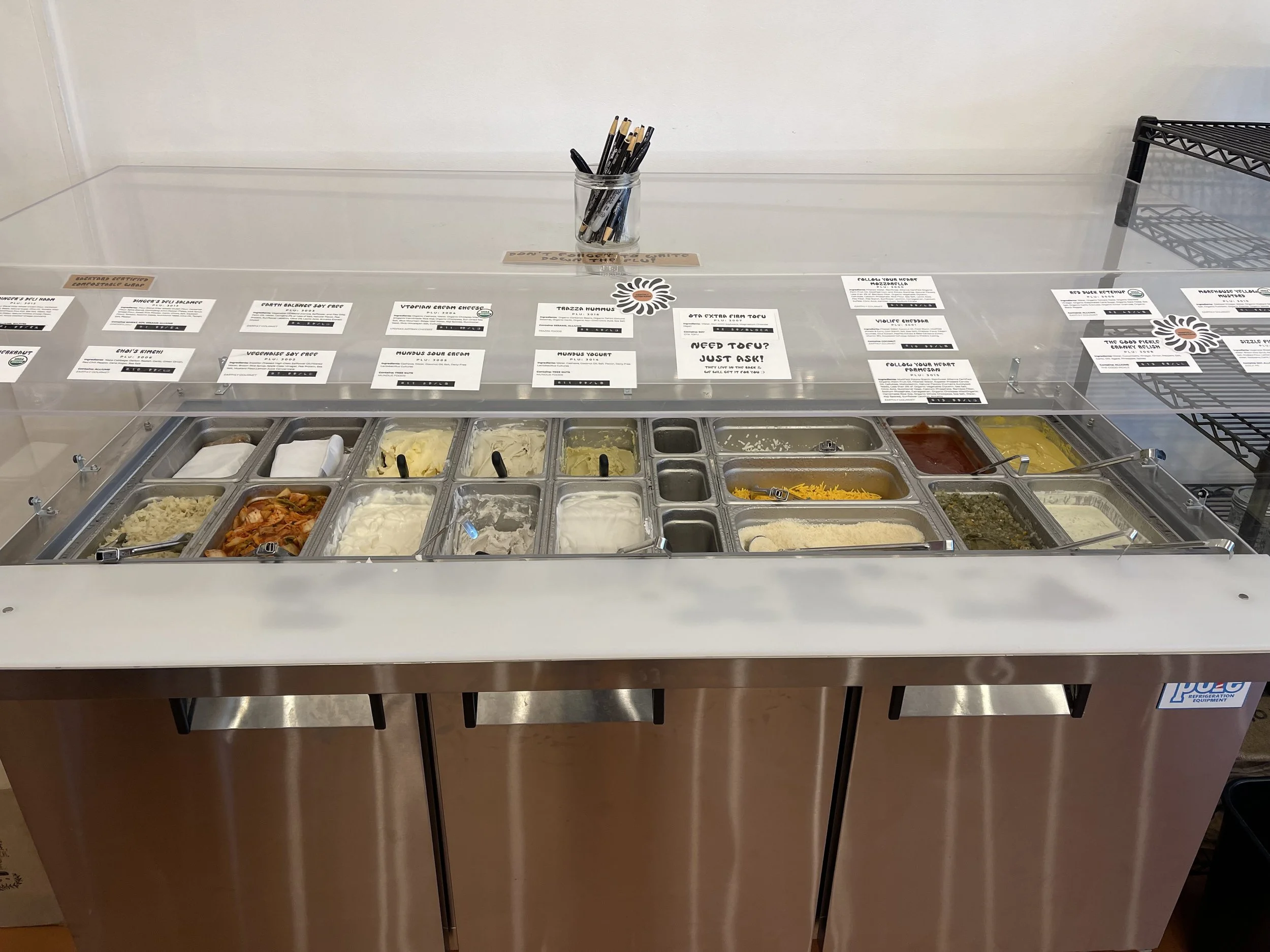 All kinds of cheeses, sauces, yogurts, and more at The Realm Refillery’s Deli Counter. Image: Dan Meyers