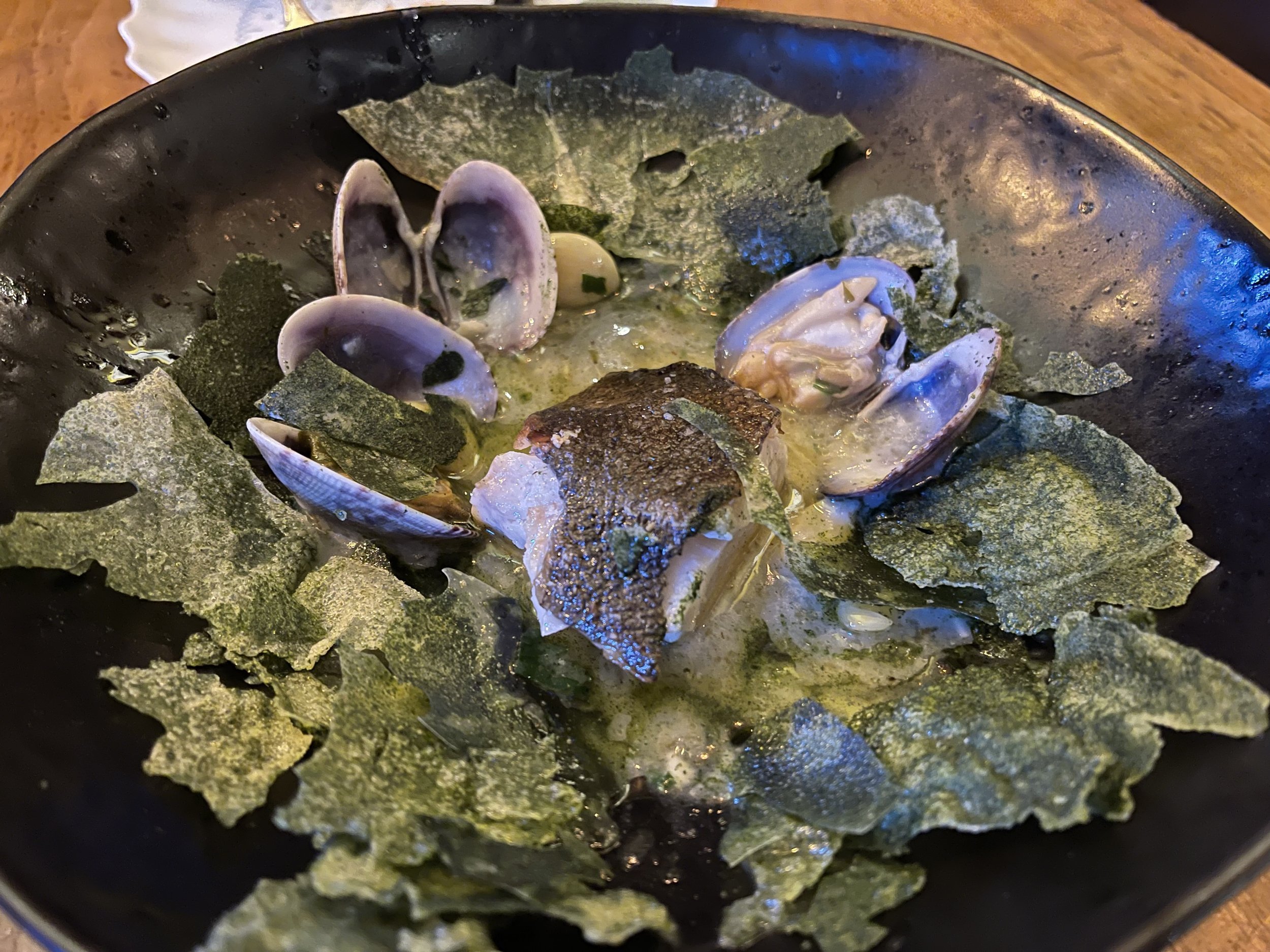 After piercing the shell of the Bacalao en Salsa Verde you’re treated to this gorgeous display containing black cod, clams, Basque salsa verde, confit garlic, parsley mache, pickled fresnos, and smoke. What an experience! Image Courtesy: Dan Meyers