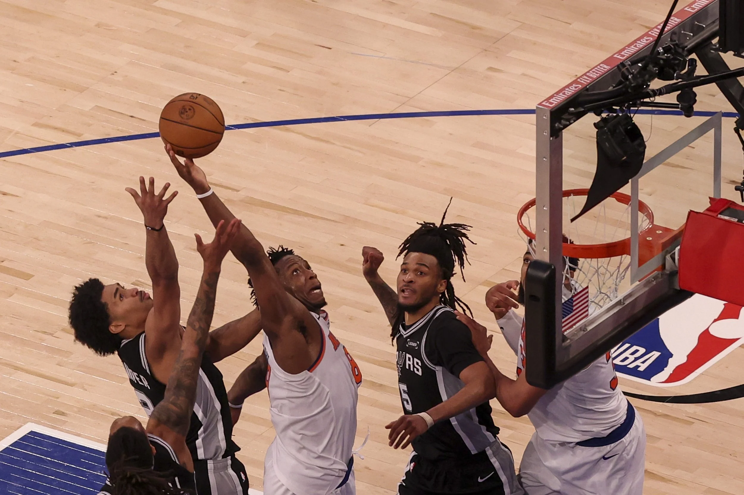  New York Knicks forward-guard OG Anunoby (2L) assists a rebound to gain a lead over the San Antonio Spurs during Game 4 of the NBA Finals, played between the San Antonio Spurs and New York Knicks at Madison Square Garden in New York, New York, USA, 