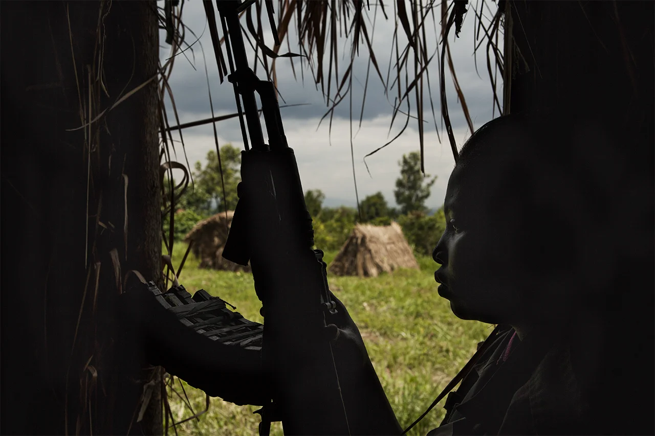 Lieutenant Rehema Rahijya doesn’t know her date of birth. She has malaria but she is not taking any drugs because in the military base there are no medicines. She was born in Nyamilima. She joined Mai Mai Shetani/FDP after some criminals attacked her family: they raped her sister and stole the animals. She doesn’t want to get married and she thinks in the future she won’t find any job because she has been a fighter. Buramba military base, Nyamilima, North Kivu, DRC