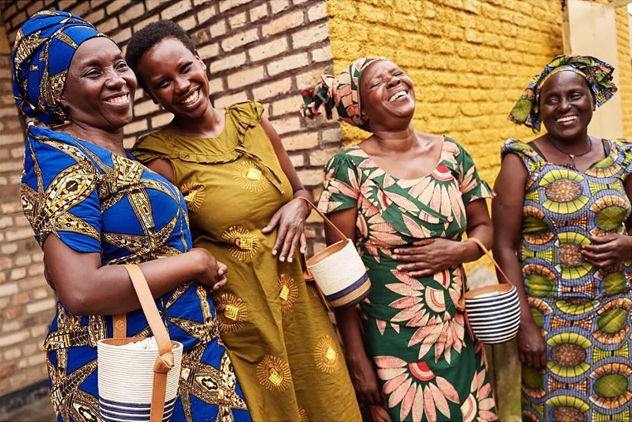 Image 2 : Rwandan artisans holding Cesta Collective woven baskets and bags, that are made from biodegradable and renewable materials by Rwandan women. Rwandan weaving is an heirloom tradition that is passed down from mother to daughter, from generation to generation. By employing these women and creating a structure where Rwandan women can become Master Weavers and oversee a weaving collective, Cesta provides opportunity for growth and leadership, for women to become the breadwinners of their families, allowing their families to flourish thanks to the work they do.