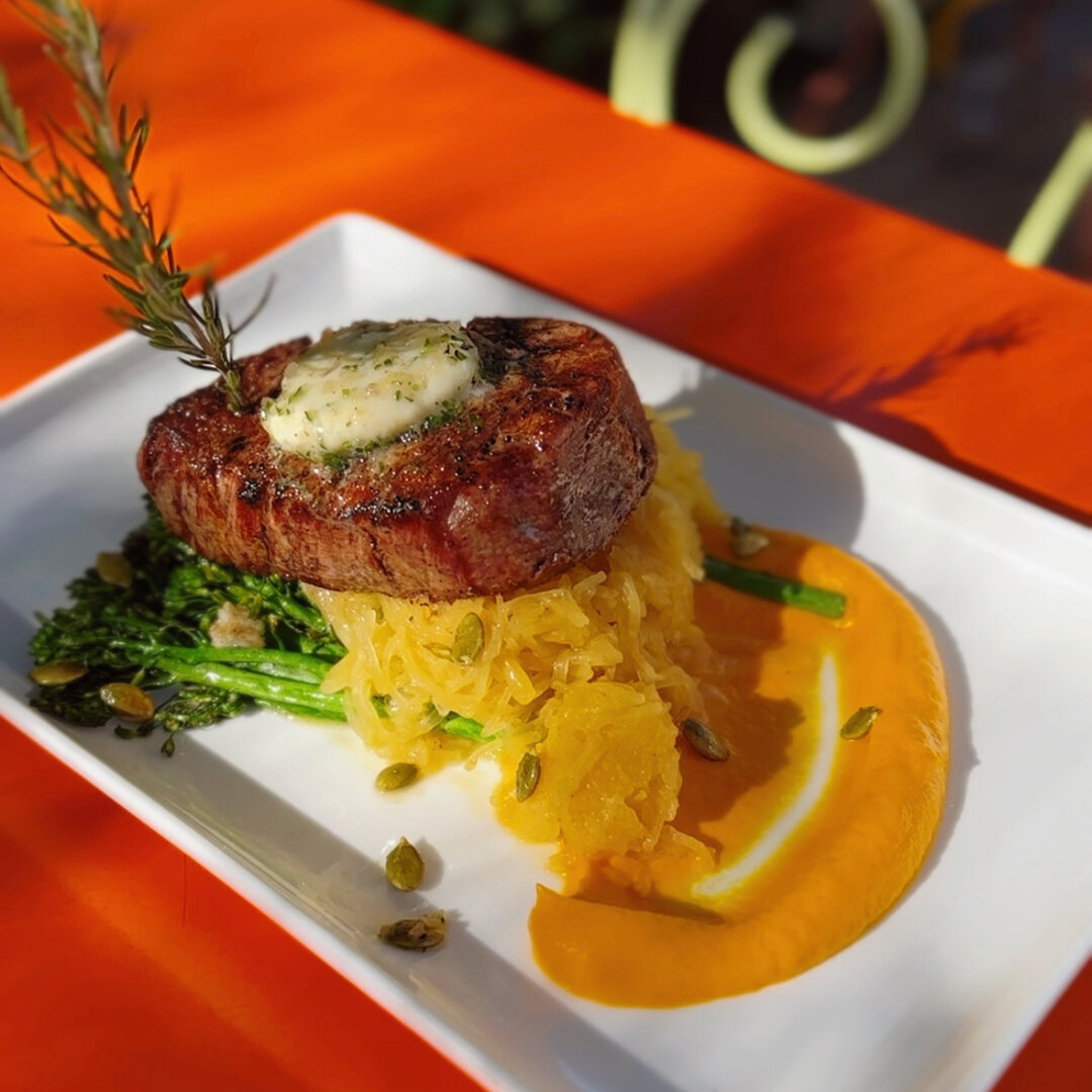 Savor the elegance of fall with our 8oz Filet Mignon, perfectly seared and served with roasted broccolini, market squash, curried pepitas, creamy carrot pur&eacute;e, and herbed b&eacute;arnaise compound butter.