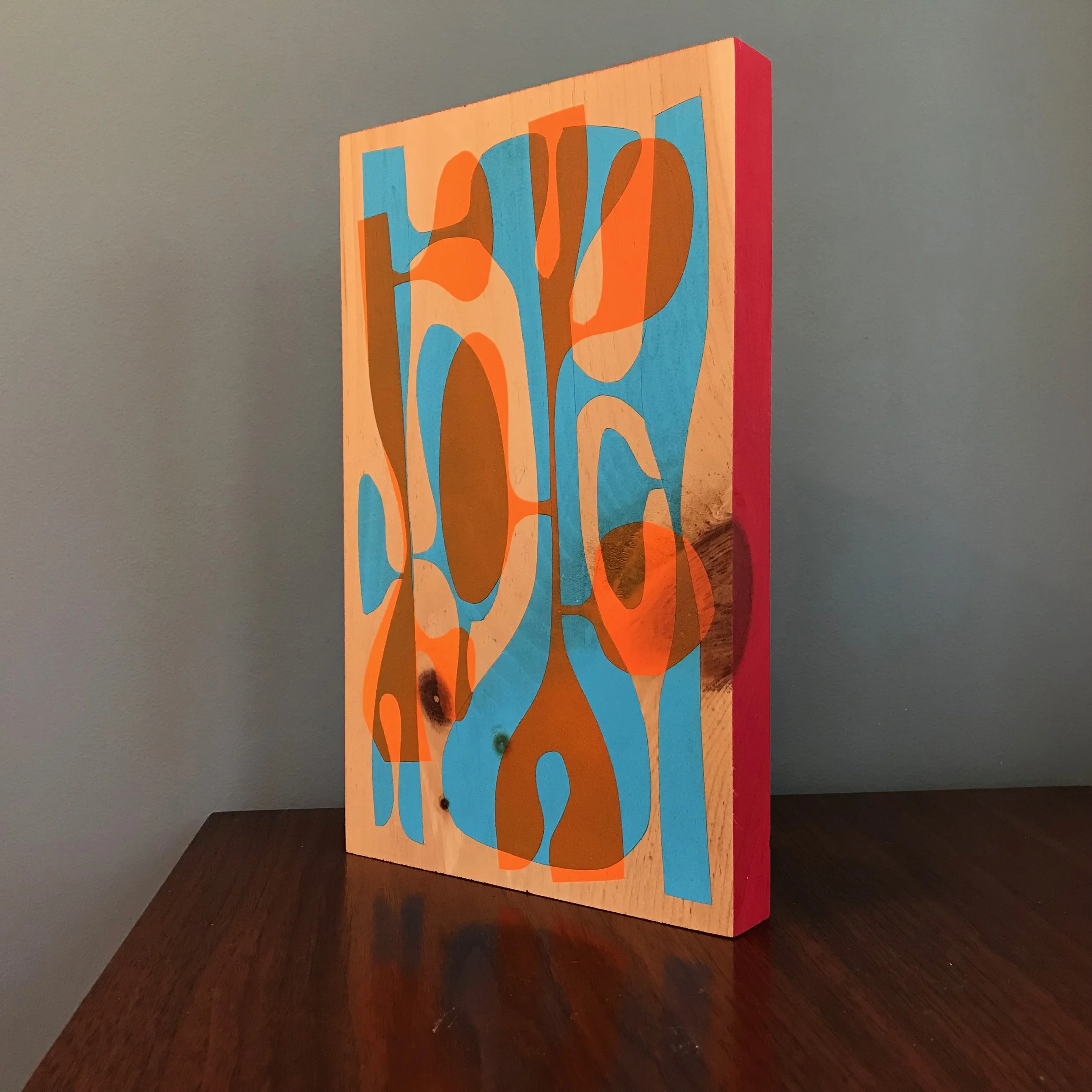 large painting with neon orange and cyan blue shapes with rocket red edge