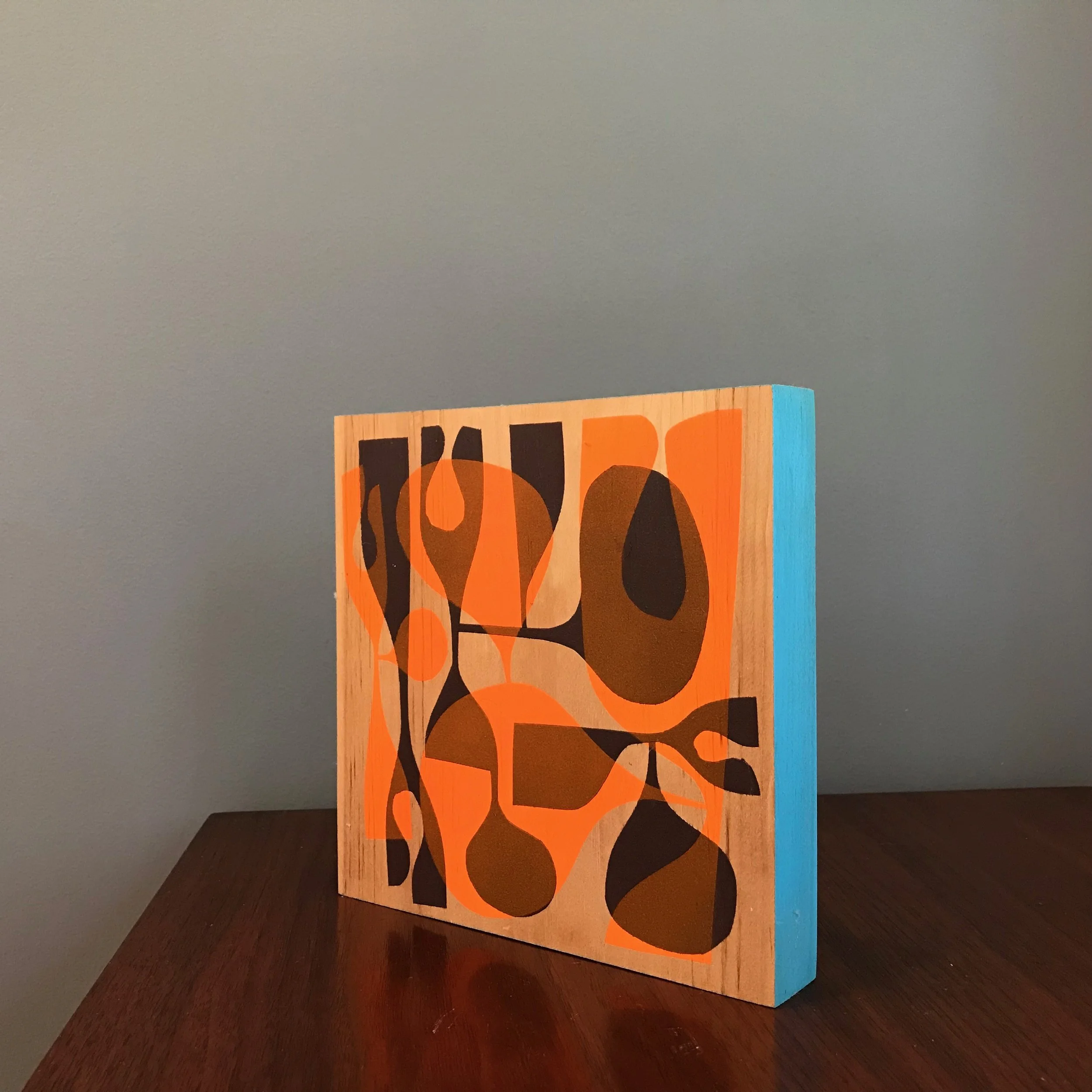 small painting with neon orange and black shapes with cyan blue edge