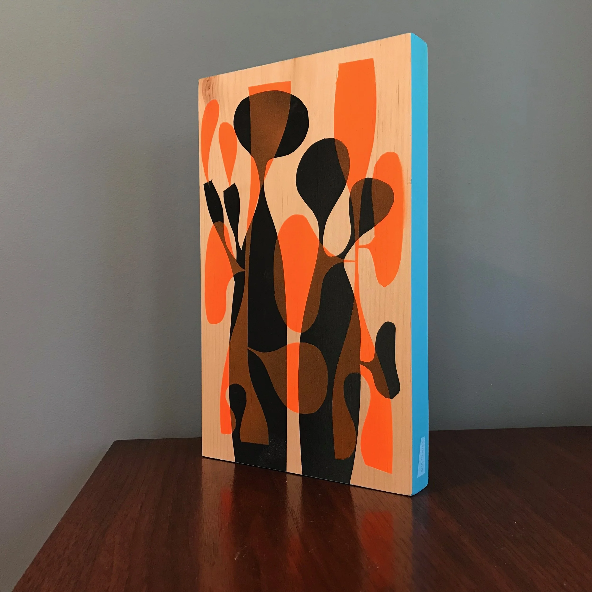 large painting with black and neon orange shapes with cyan blue edge