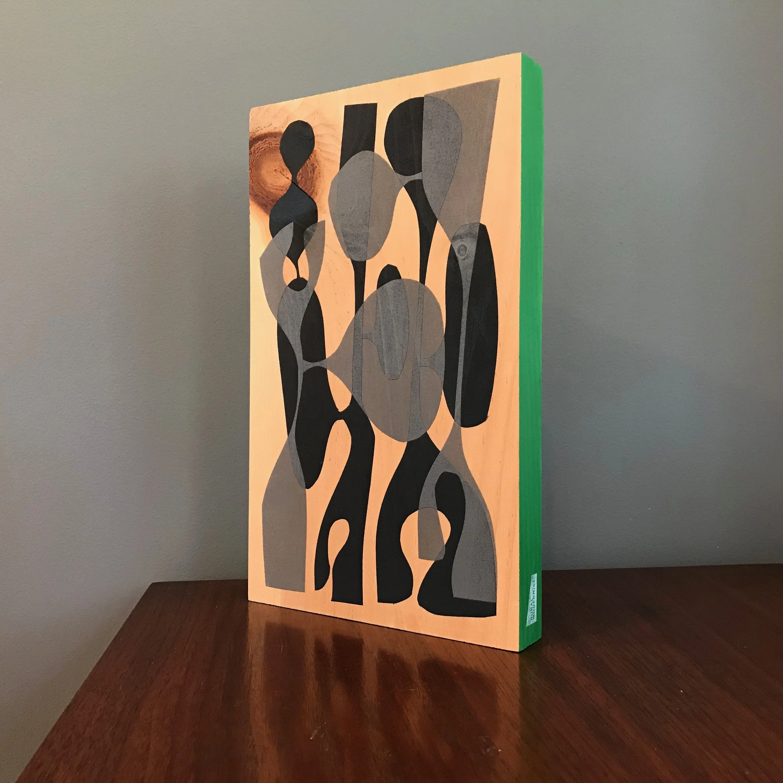 large painting with black and gray shapes and kelley green edge