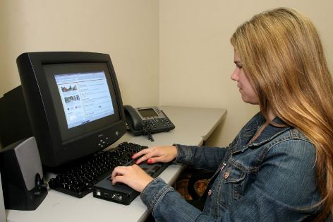 Young vision-impaired woman using a computer with assistive technology.