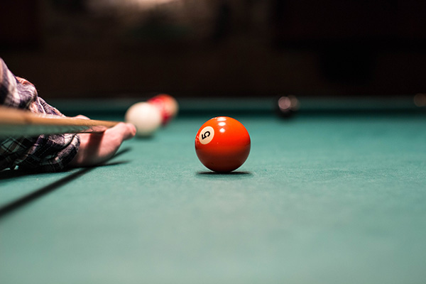 A billiard player shooting a ball. The aim and skill is like what it takes to work on your local SEO if your aim is to win with your website SEO for local listings.