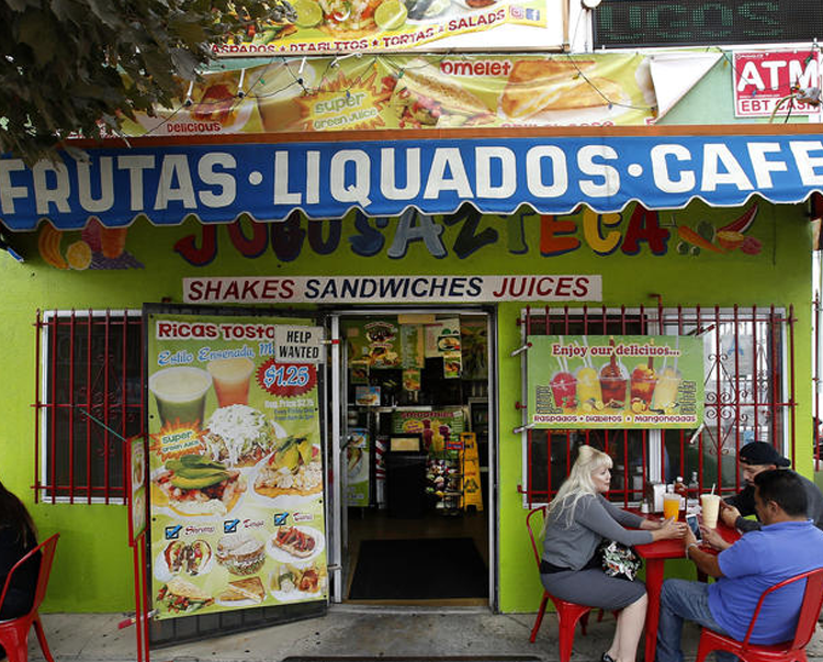 In a time when cold-press juiceries are relentlessly on trend, and often relentlessly expensive, Jugos Azteca in Highland Park is keeping juices old-school. For the last 21 years, the tiny juice shop on York Boulevard has been making Mexican-style fruit and vegetable juices, smoothies, tortas, tostadas, Mexican-style gelatin and other simple Mexican snacks for the Latinos who’ve lived in the neighborhood for decades, as well as some of the newer residents who appreciate the value and the flavors of the fresh and colorful drinks. “We have customers who are waiting for us to open at 5:30 a.m. every day to get a green juice for breakfast and then a torta for lunch before they go to work,” said the shop’s owner, Efrain Peña, 44, in Spanish, as he took a break from recording his daily sessions on Instagram . The small, neon-green building that houses Jugos Azteca stands out from the rest of the neighborhood’s newer style of muted colors. Signs advertising everything from “Ricas Tostadas” to “Diablitos” and the red tables and chairs outside are as colorful as the juices themselves.