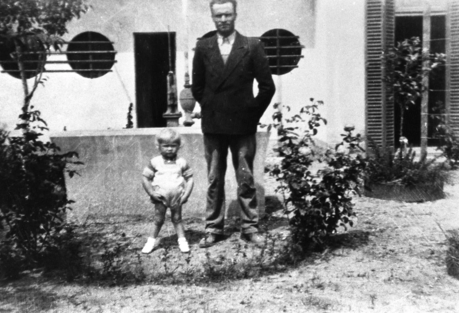 A young Luis standing with his father, Luis Palau Sr., outside their home in Ingeniero Maschwitz, Argentina (1937).