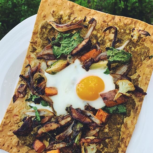 lavash pizza for dinner🍕🥰 topped with pesto, @rosecreekfarms spinach, @bluffcityfungi mushrooms, sweet potatoes, caramelized onions, Brussels sprouts, cauliflower @traderjoes nutritional yeast (totally optional but adds more of a cheesy flavor), an