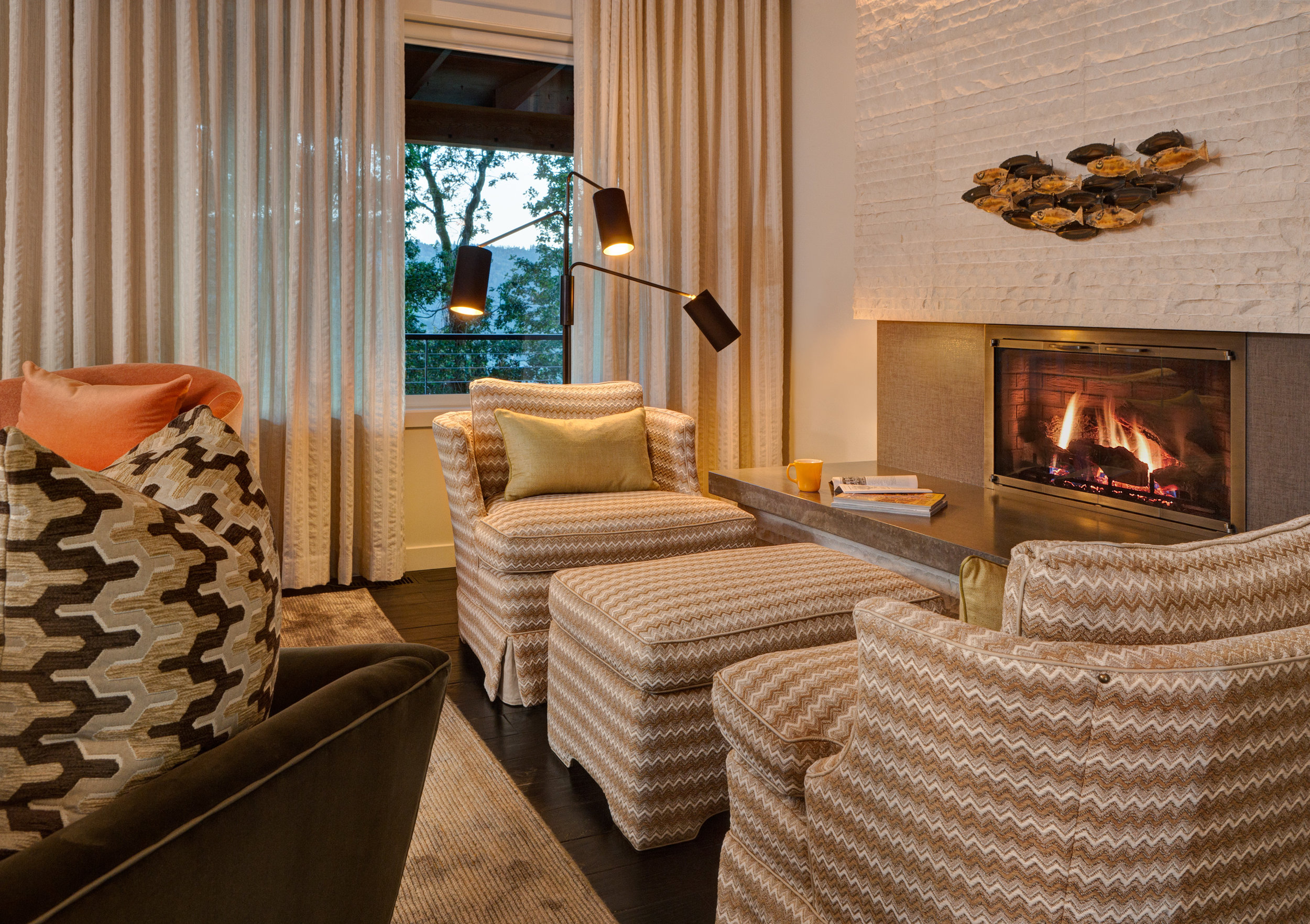 St. Petersburg chiseled limestone wall tile from Ann Sacks surrounds the fireplace.