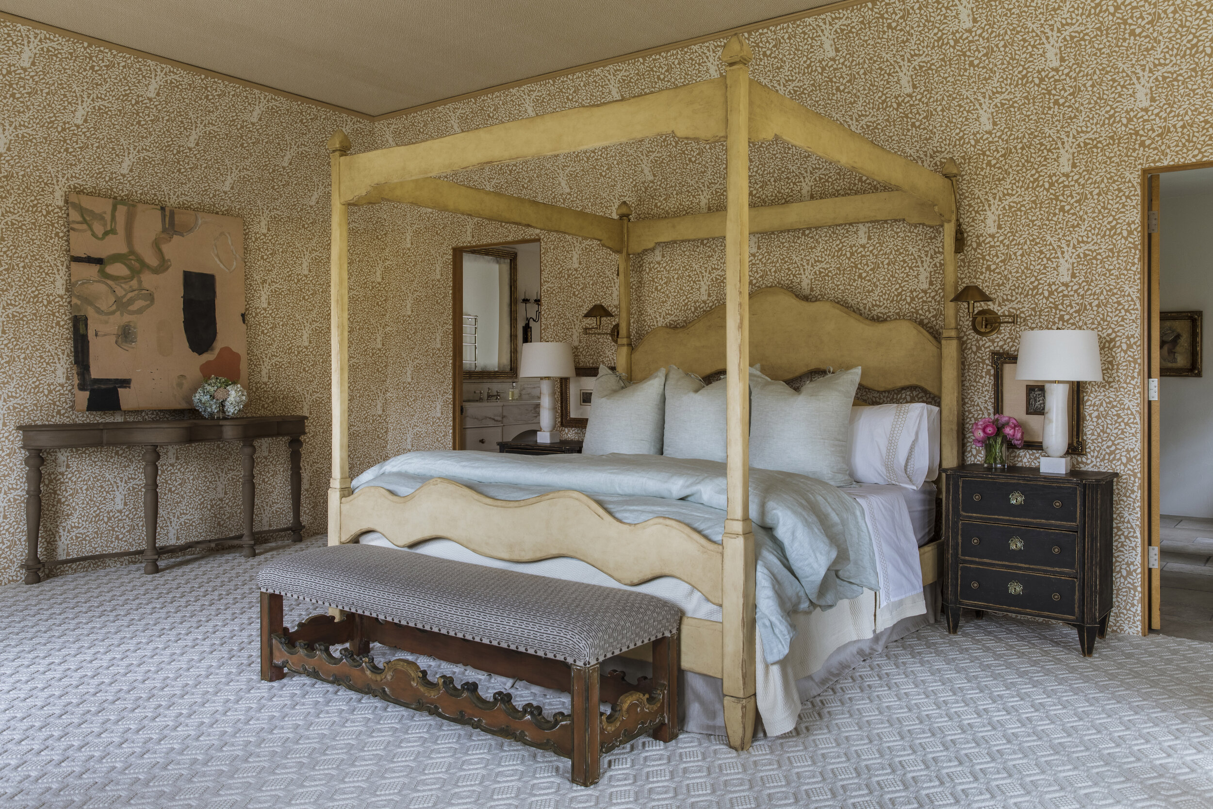  A China Seas wallcovering was part of the master bedroom's new look. At the foot of the bed, dressed in linens from French Quarter, is a bench in a Lee Jofa fabric. The table lamp is by Vaughan; the carpet is by Stark. 