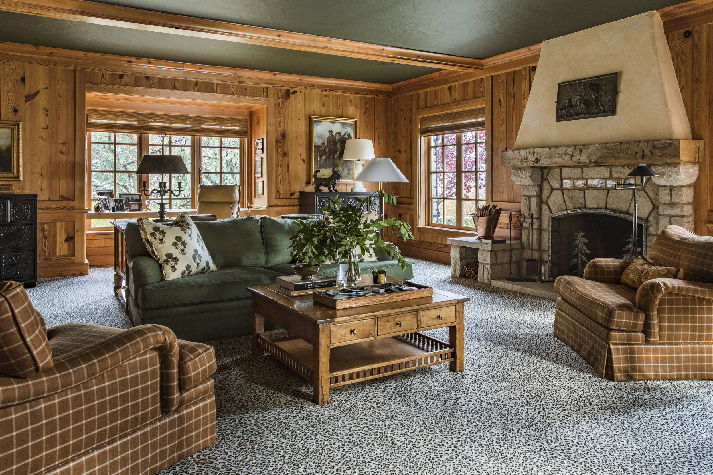  The den’s leopard pattern carpet is paired with rust-hued plaid armchairs.  