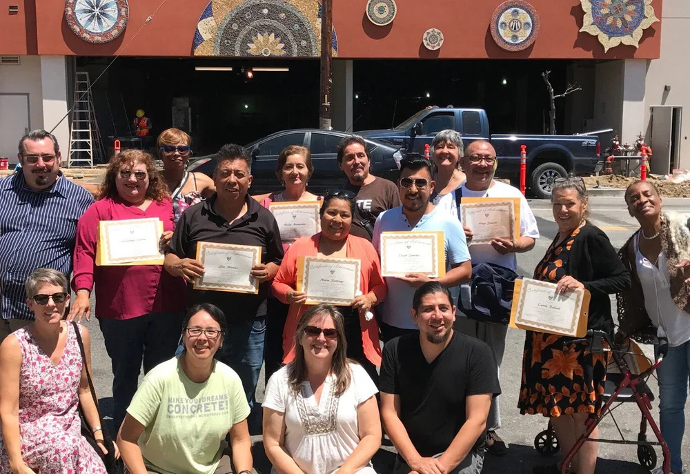 Piece by piece participants and instructors posing with their newly installed mosaic mandalas in May 2017 for teh legal aid foundation of los angeles’ headquarters, located at 8th street and union.