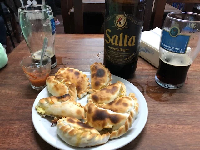 A sampling of empanadas from El Patio de Empanadas in Salta. These were the best beef empanadas that we tasted. The cheese - not so much. Note the red tomato salsa in the drink glass at left rear.