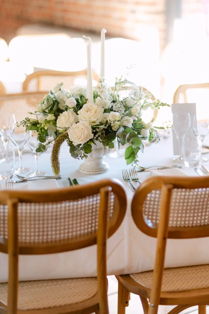 Centre de table fleuri pour un dîner chic de mariage.