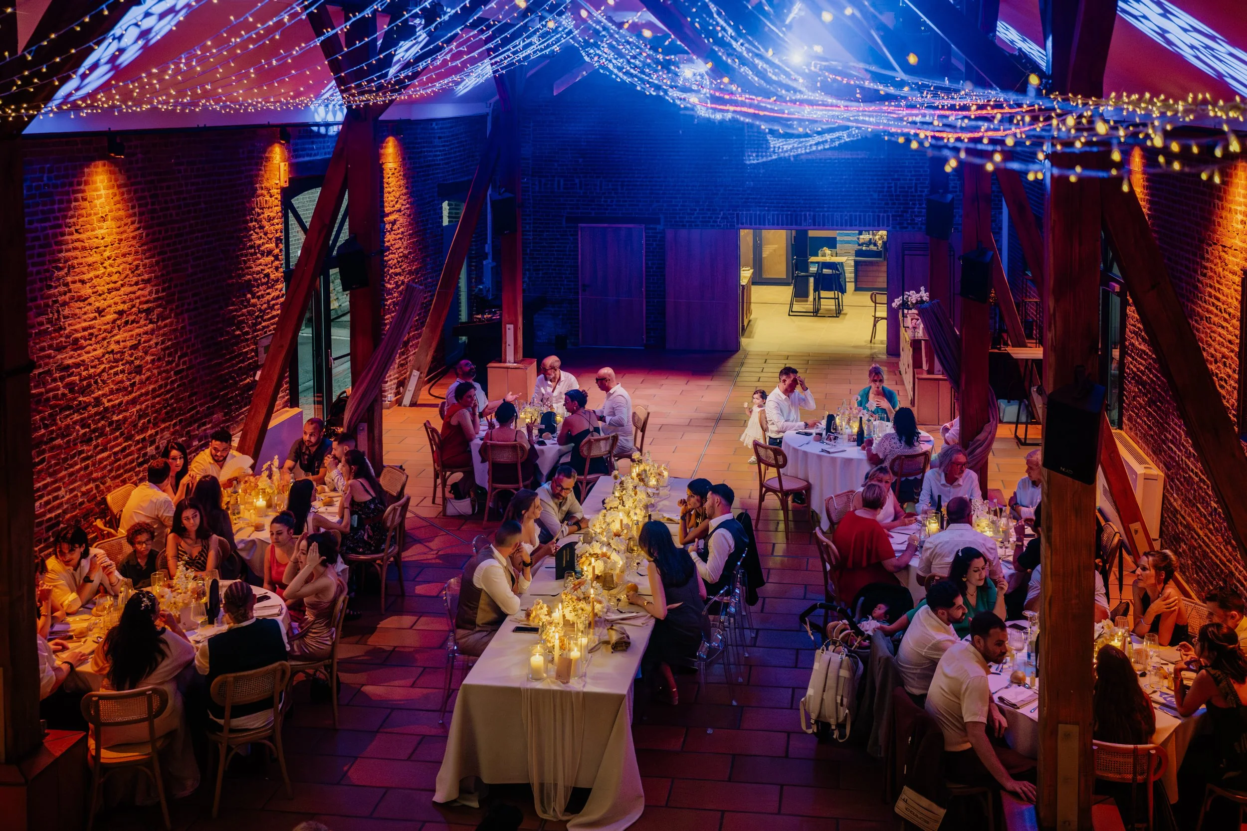 Dîner de mariage sous la charpente éclairée du Clos de la Source