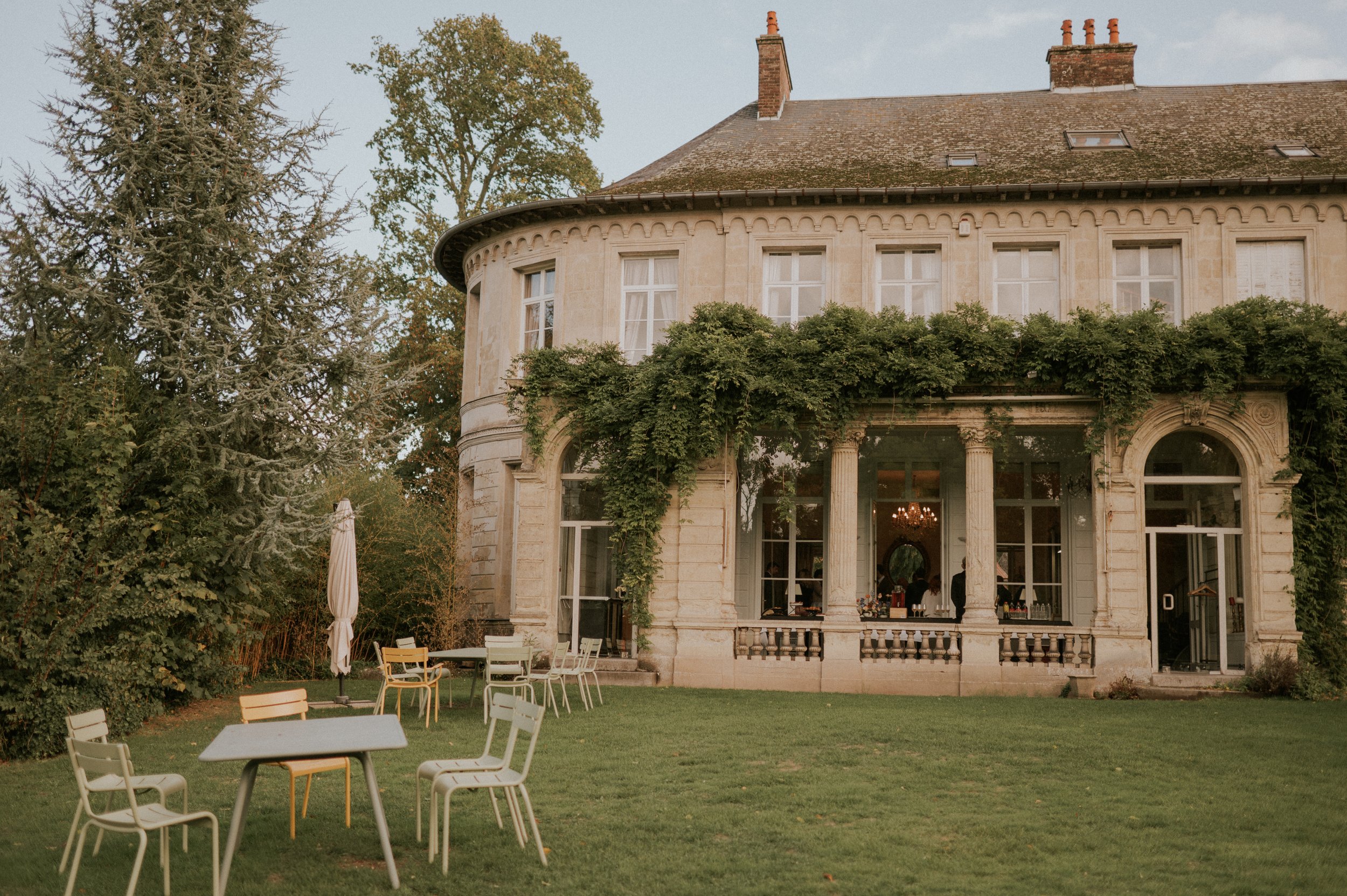 Façade du Château d’Aubry côté parc, tables dressées sur la pelouse