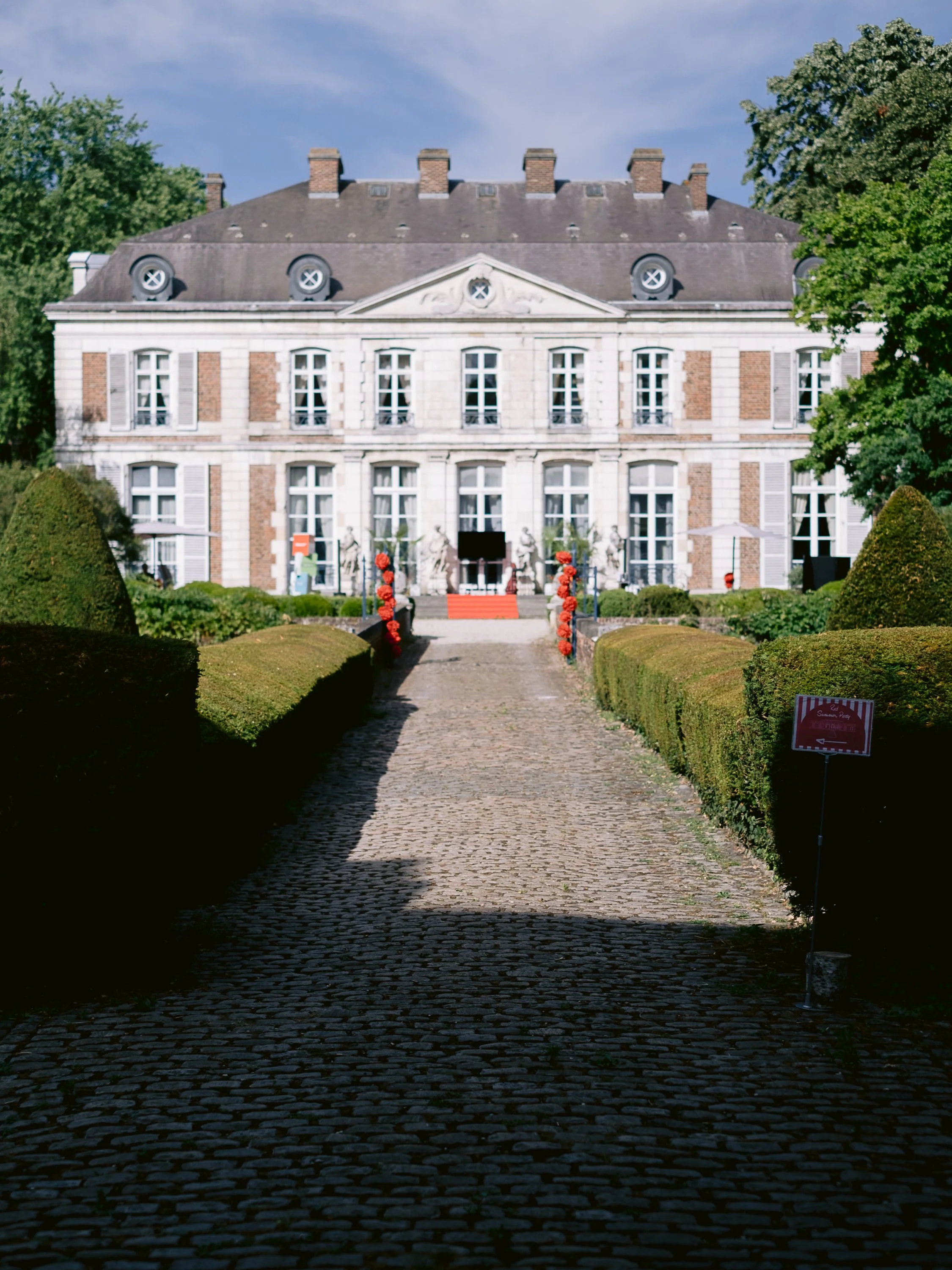 Allée pavée et tapis rouge devant la façade du Château du Vert-Bois