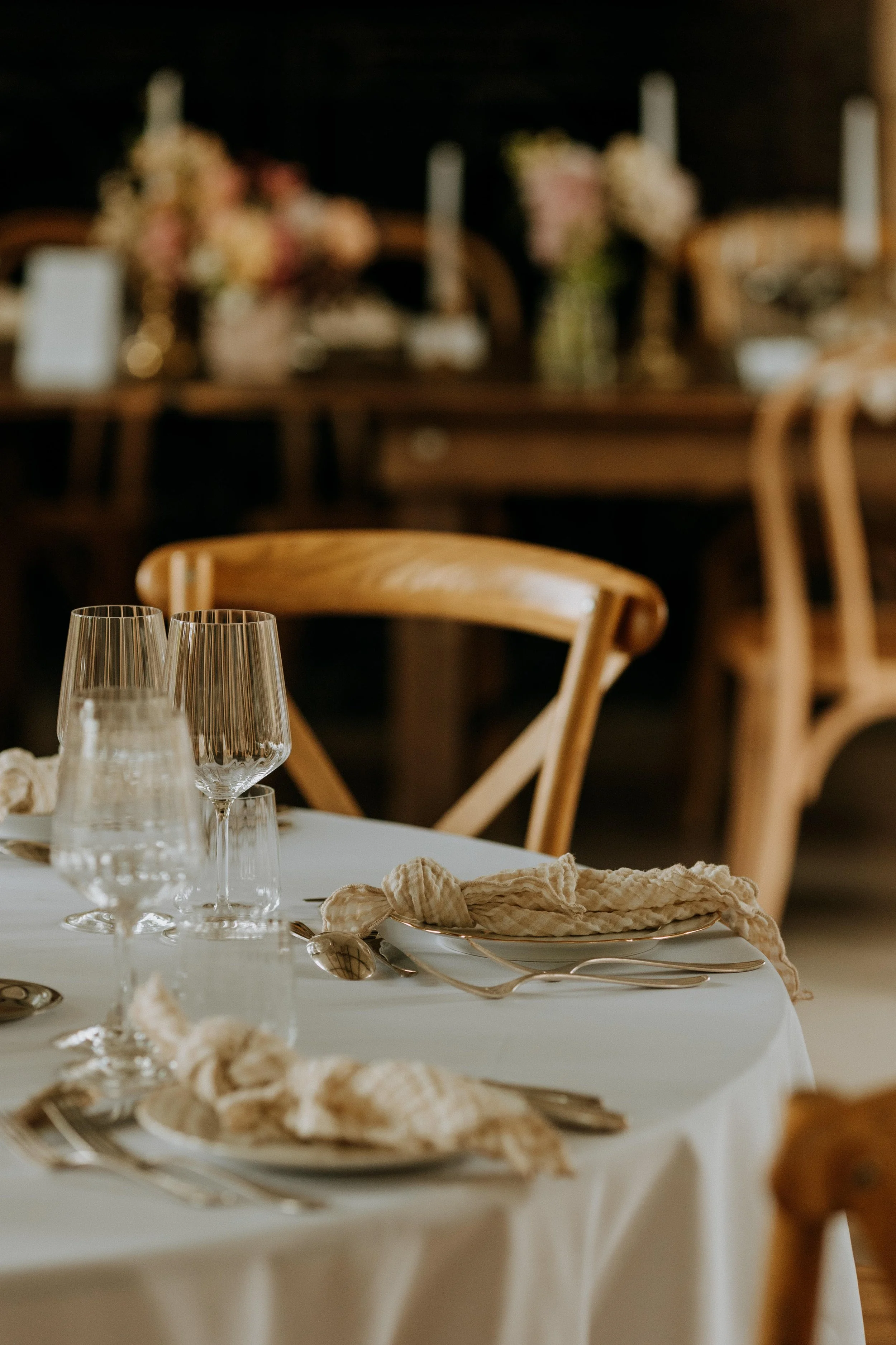 Chaise en bois et verres sur une table de mariage au Domaine d’Achelles