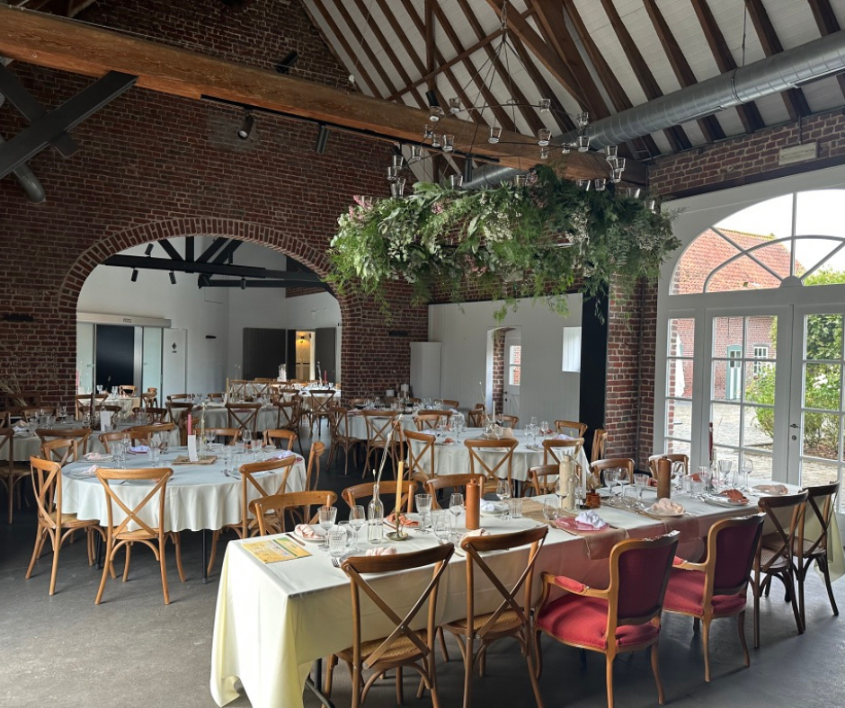 Salle du Domaine de Ronceval dressée pour un dîner, sous ses poutres et son arche en brique