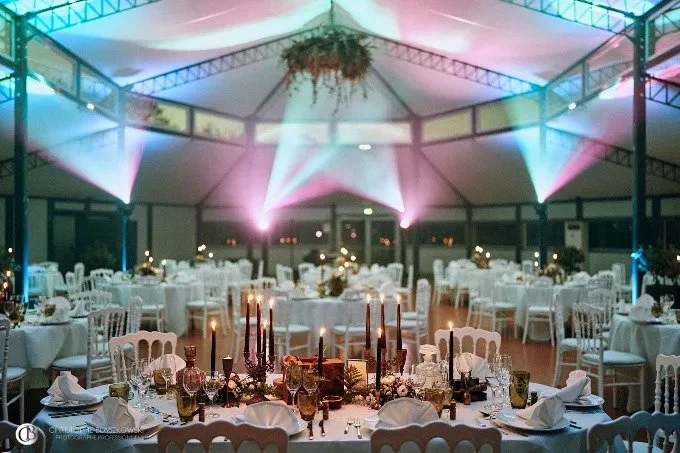 L’Orangerie du Mercure dressée pour une soirée de mariage, sous ses éclairages colorés