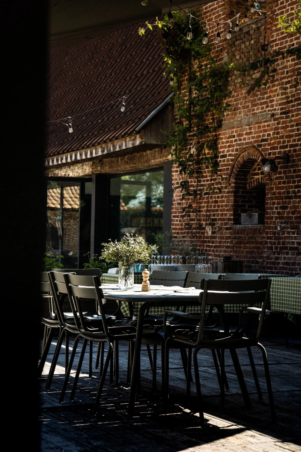 Terrasse dressée pour un dîner dans la cour de la Cense de la Vigne