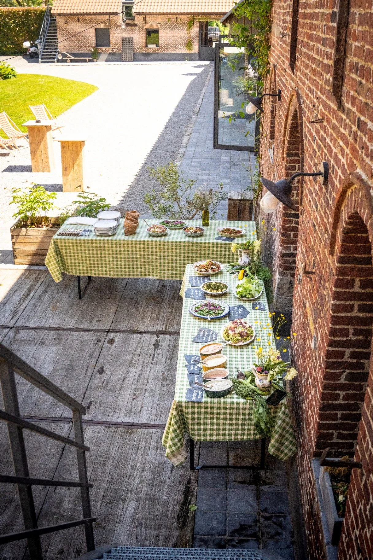 Buffet dressé en terrasse le long des murs de brique de la Cense de la Vigne