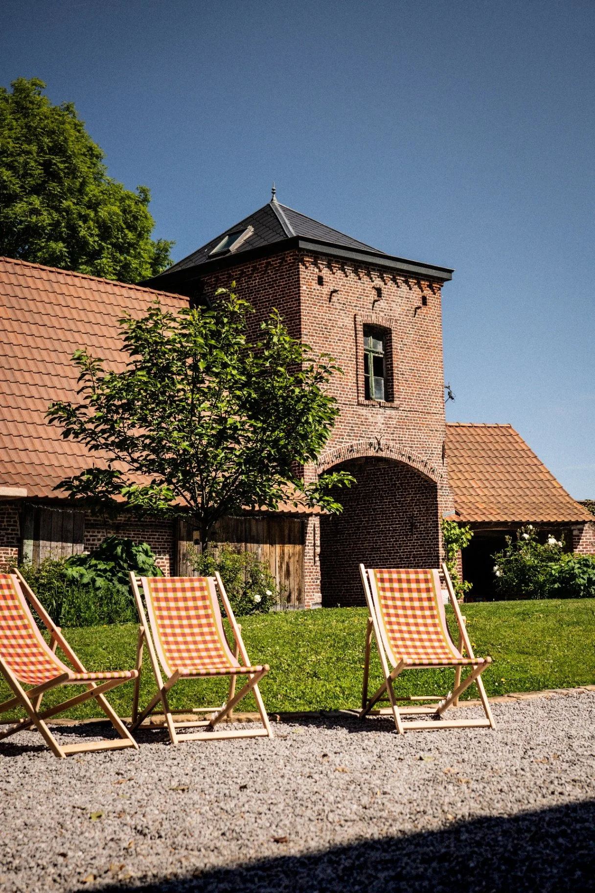 Tour-porche en brique et transats dans le jardin de la Cense de la Vigne à Wambrechies
