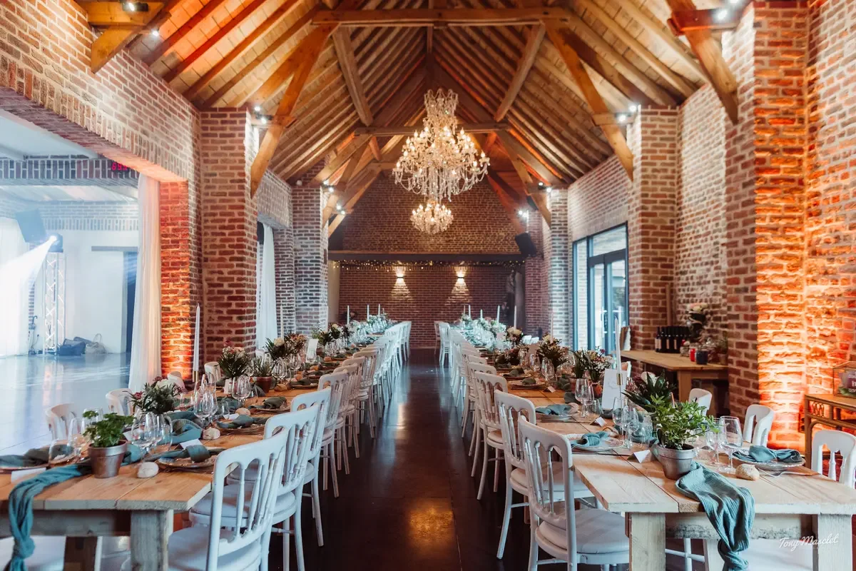 La Grange de la Ferme d’Hercule dressée pour un mariage, sous sa charpente et ses lustres