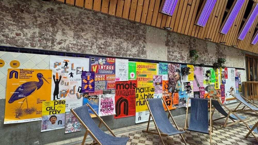 Transats devant un mur d’affiches dans la rue couverte de La Condition Publique