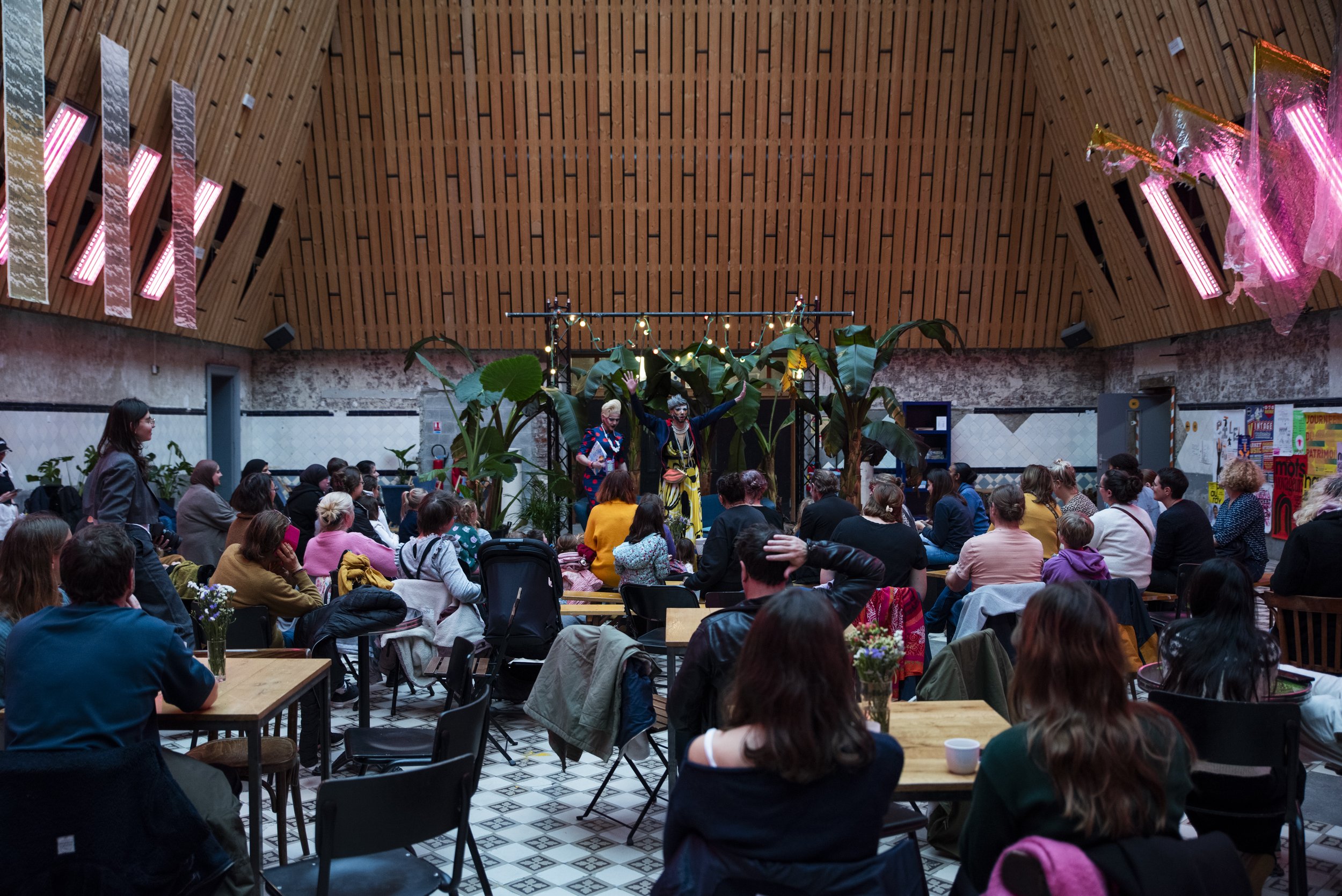 Conférence dans une halle de La Condition Publique, public attablé sous la charpente en bois