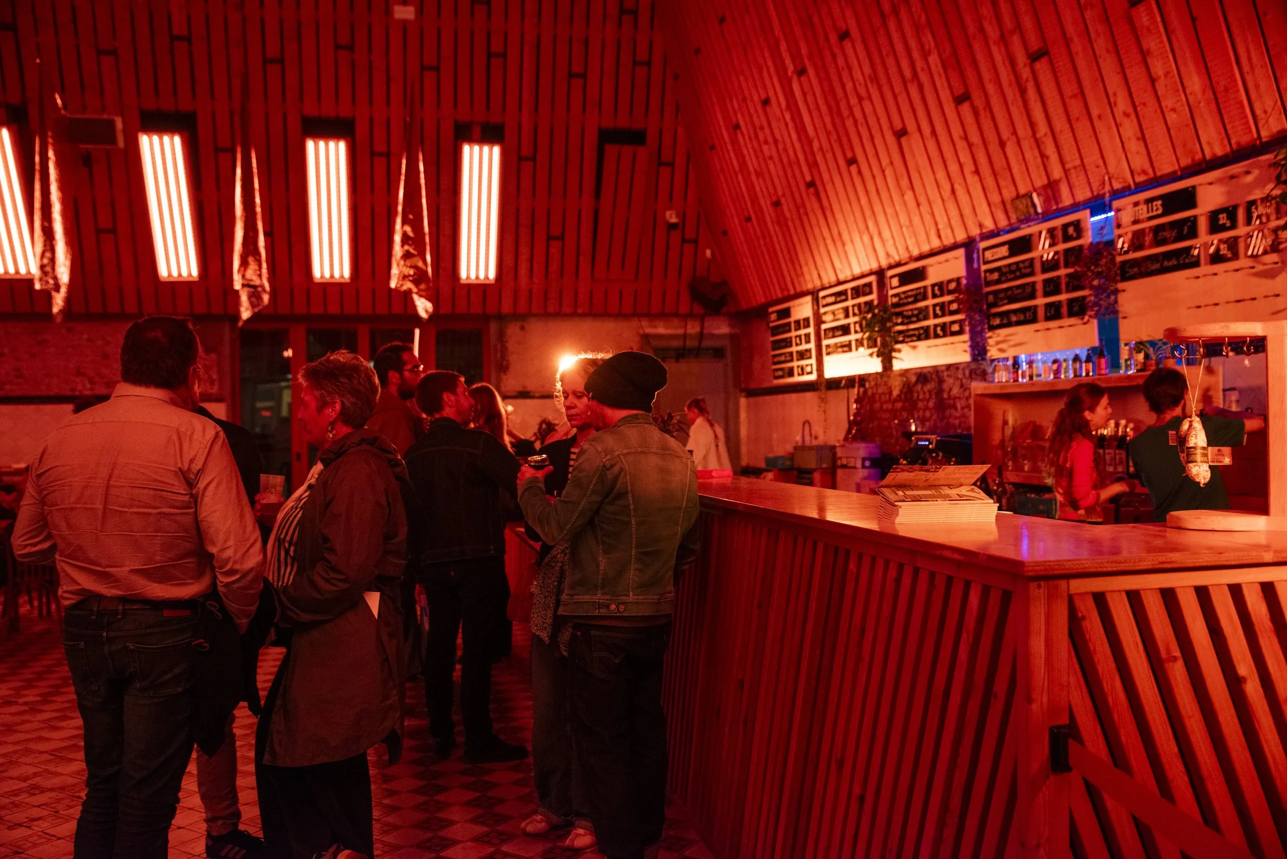 Le bar de La Condition Publique à Roubaix, ambiance soirée sous lumière rouge