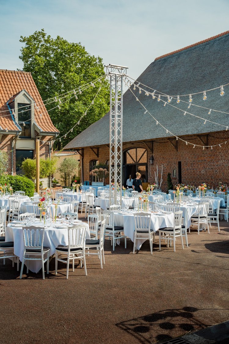 Mariage sous les étoiles : tables rondes dressées dans la Cour du Clos de la Source, sous les guirlandes