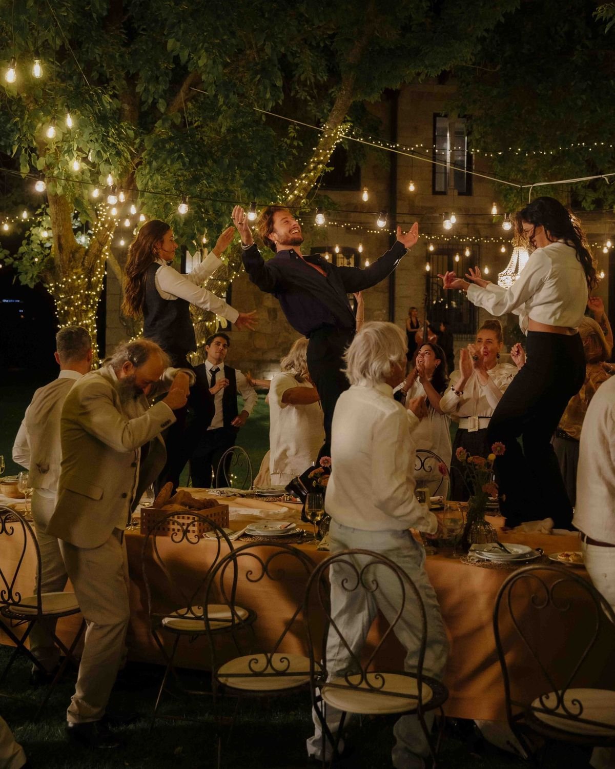 Dîner en extérieur sous guirlandes lumineuses servi par La Gourmandine