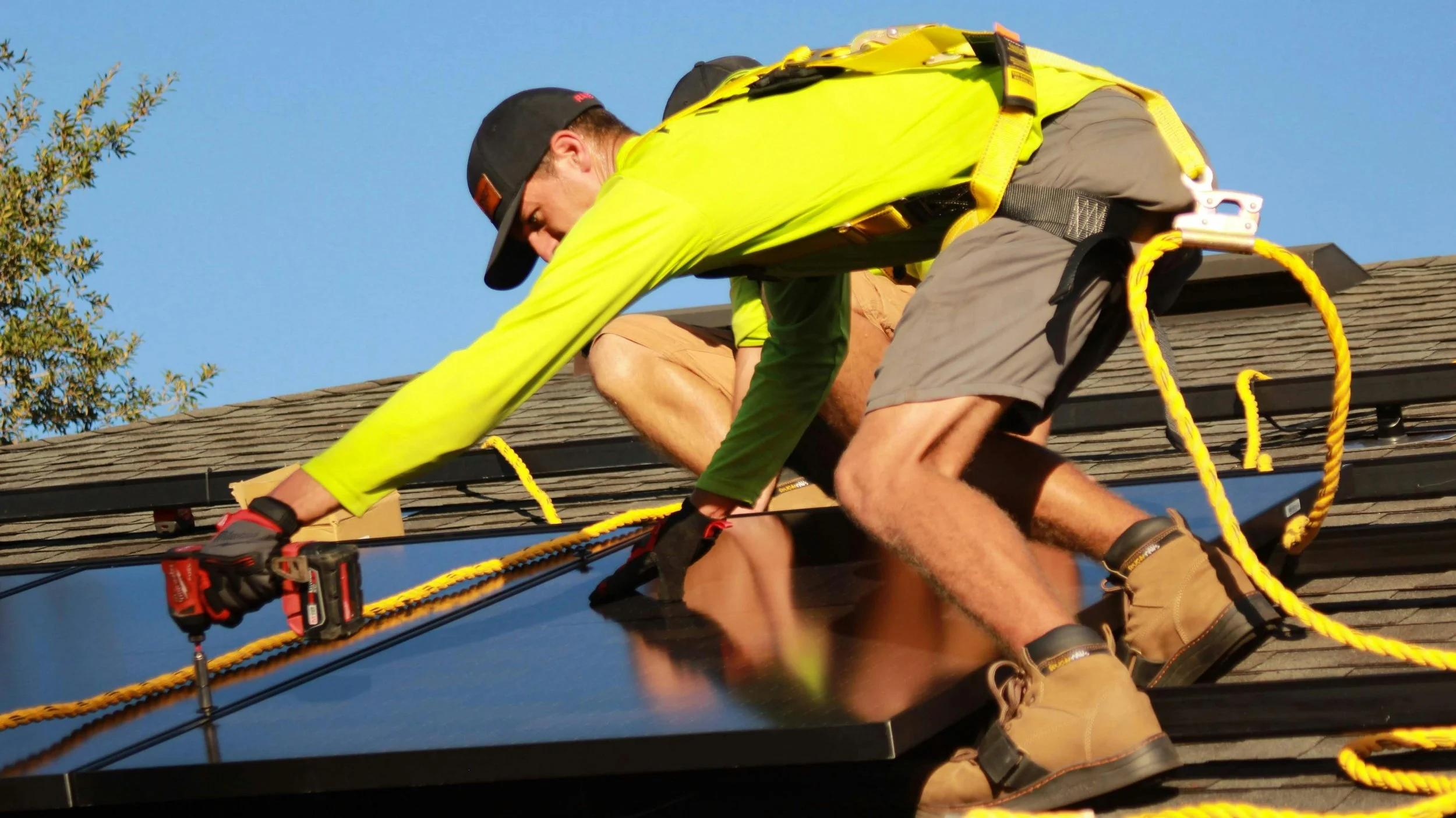 worker on top of roof installing solar panels