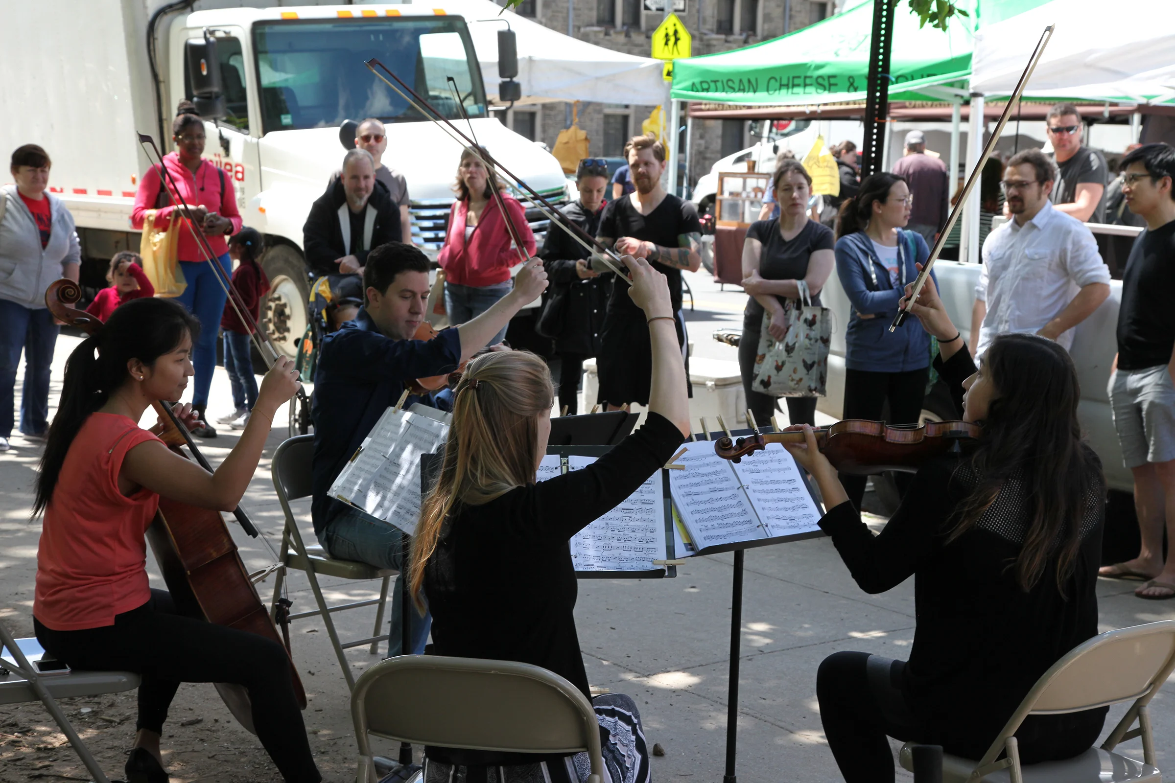 Northern Manhattan Arts Alliance - Performance by Ulysses Quartet, spectators listen closely at the Inwood Farmers Market / Photo by Gary Santana